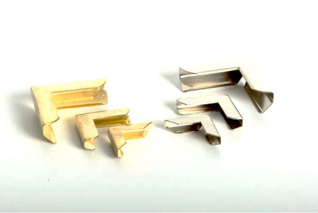 Esquinero metálico en escuadra de 17 mm, disponible en acabados níquel (plateado) y oro (dorado). Perfectos para protección y decoración de esquinas en encuadernación y manualidades. Empaque disponible en caja de 25000 piezas o mínimo de 2500 piezas por modelo. Esquinero metálico en escuadra de 17 mm, disponible en acabados níquel (plateado) y oro (dorado). Perfectos para protección y decoración de esquinas en encuadernación y manualidades. Empaque disponible en caja de 25000 piezas o mínimo de 2500 piezas por modelo.